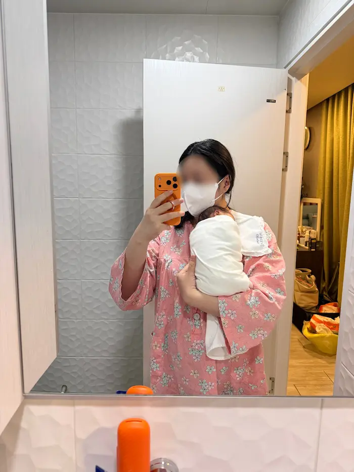 Mother holding her newborn baby inside a Korean Postpartum Care Center