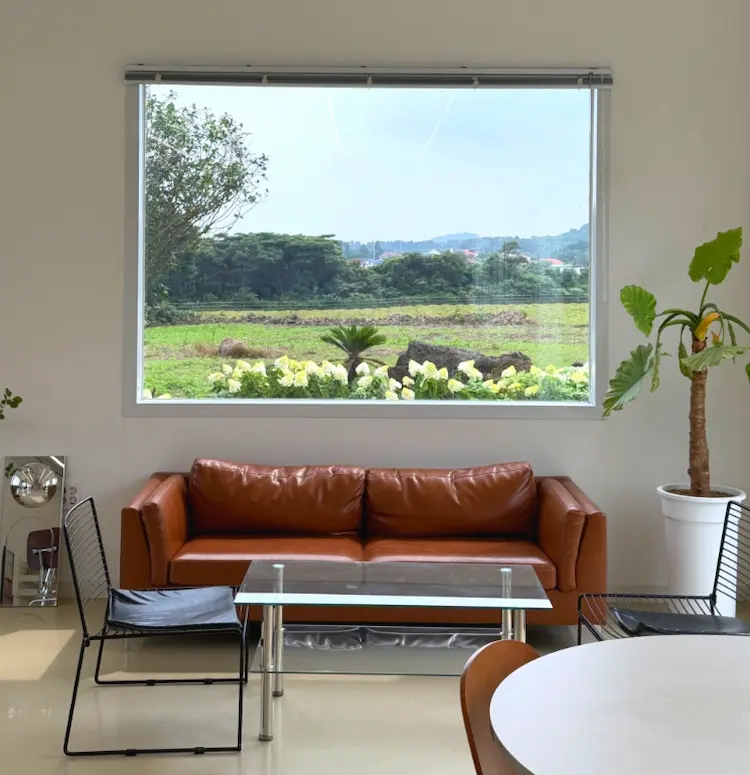 Large window overlooking Jeju countryside at Alps Jeju Cafe