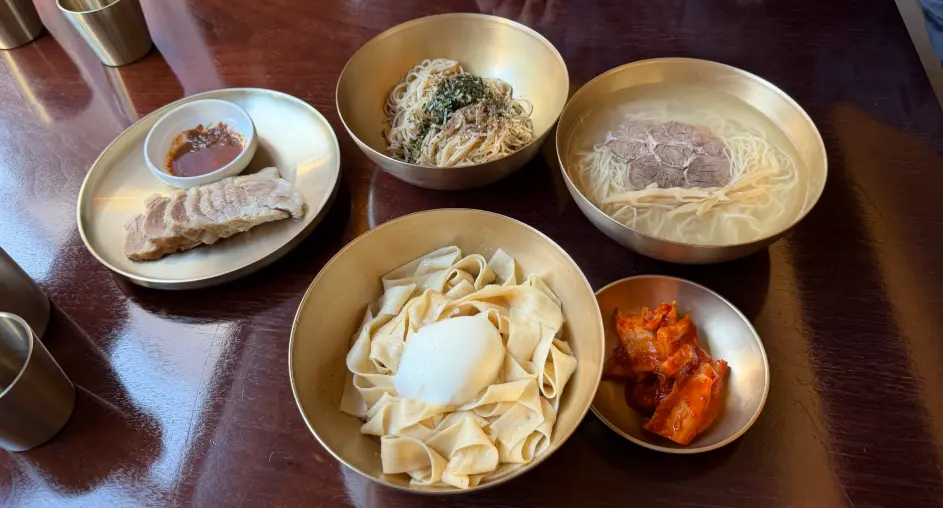 Signature noodle dishes and pork served at Myeon Seoul